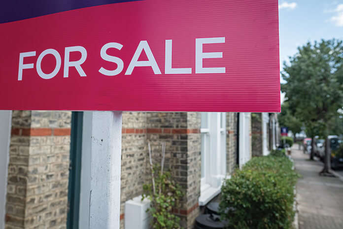 For sale sign outside an house on a street