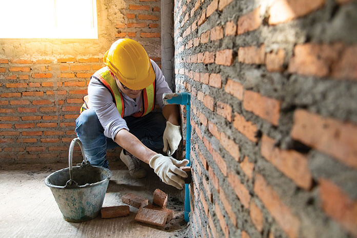 A Builder working on a brick wall