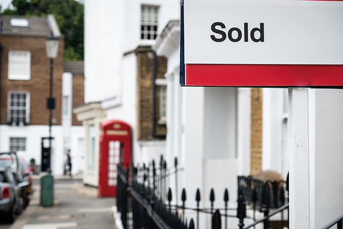 A sold sign outside a house on a upmarket street
